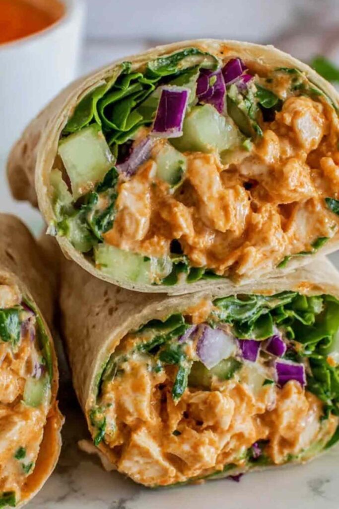 BBQ Grilled Chicken Wraps cut in half showing grilled chicken strips with BBQ sauce, fresh vegetables, and ranch dressing wrapped in flour tortilla