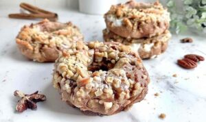 Vegan apple pecan streusel bagels on a white plate with pecan topping and apple filling