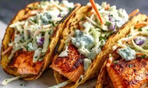 Air fryer salmon tacos with cabbage slaw and lime on a white plate