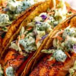 Air fryer salmon tacos with cabbage slaw and lime on a white plate