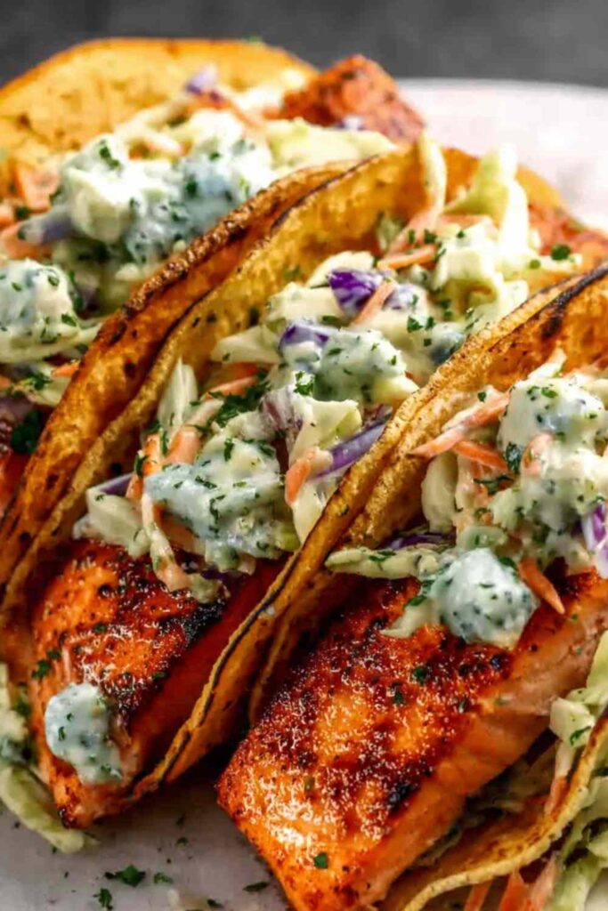 Air fryer salmon tacos with cabbage slaw and lime on a white plate