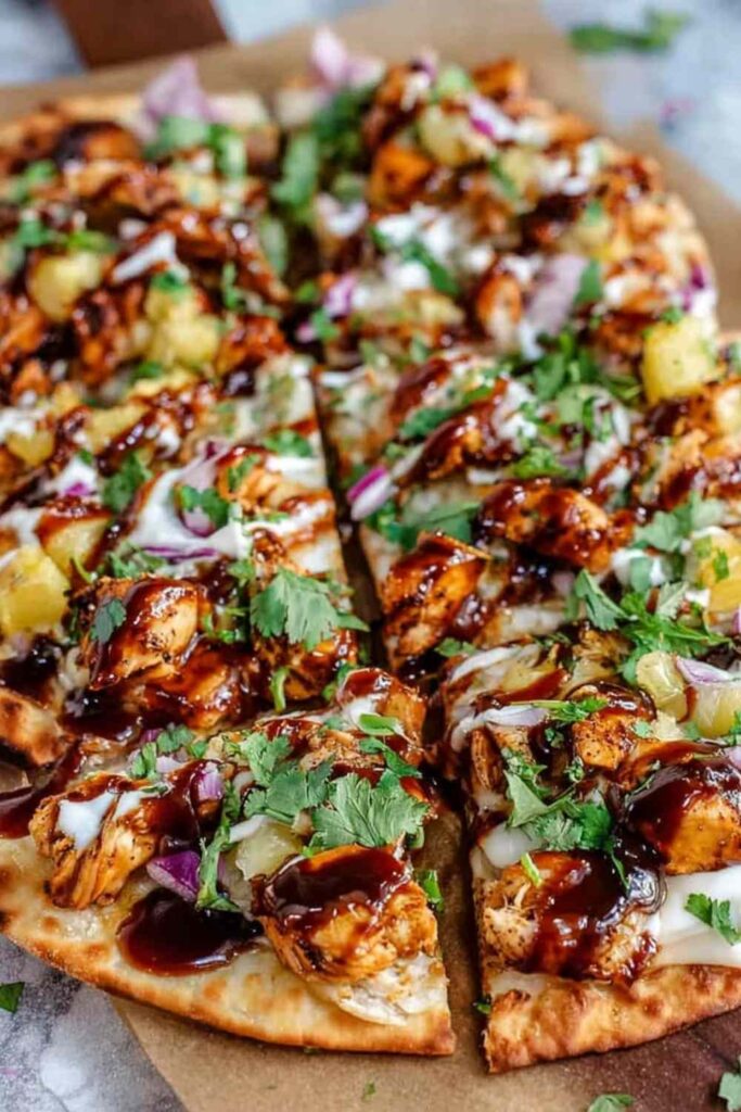BBQ chicken flatbread with melted cheese and cilantro on white plate