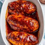 Baked BBQ chicken breast on white plate with caramelized sauce