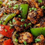 Black pepper chicken stir-fry with bell peppers and green onions in a skillet