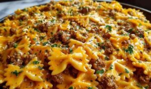 Cajun Cream Cheese Alfredo Bowties with spiced ground beef served in a white bowl garnished with fresh parsley