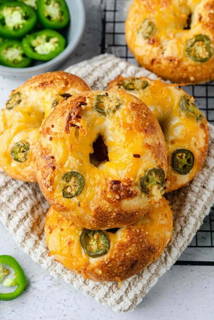 Golden brown jalapeno bagels with everything seasoning on cooling rack