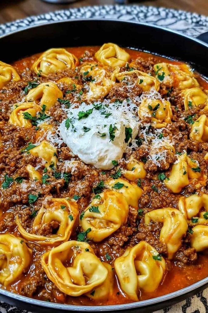 Cheesy Beef Enchilada Tortellini 6 Cheesy beef enchilada tortellini in a skillet topped with melted Mexican cheese and fresh cilantro