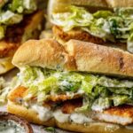 Chicken Caesar sandwich on toasted ciabatta with romaine lettuce, shaved Parmesan, and creamy Caesar dressing