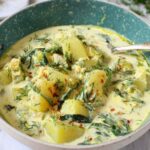 Chunky potato dill soup in a white ceramic bowl topped with fresh dill sprigs and a swirl of coconut milk