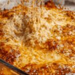 Cottage Cheese Chicken Parm Bowl with melted mozzarella cheese and fresh basil garnish in white bowl