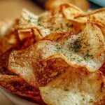 Crispy golden Protein Cottage Cheese Chips on white plate with bowl of salsa
