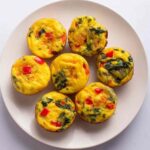 Cottage cheese egg bites in muffin tin fresh from oven with golden tops