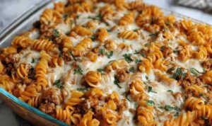 Cottage cheese protein pasta bake in white baking dish with melted mozzarella cheese and fresh basil garnish