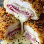 Creamy chicken cordon bleu in a skillet with melted Swiss cheese, ham, and Dijon cream sauce garnished with fresh parsley