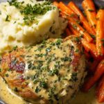 Creamy herb chicken with mashed potatoes on a white plate with fresh parsley garnish
