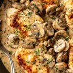 Creamy mushroom chicken in skillet with golden chicken and rich garlic sauce