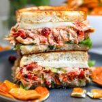 Sun-dried tomato chicken salad in a white bowl with fresh basil garnish