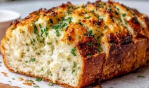 Crispy garlic Parmesan bread on a baking sheet with golden melted cheese and fresh chopped parsley