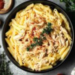 Crock pot creamy Cajun chicken pasta in a white bowl with fresh parsley garnish