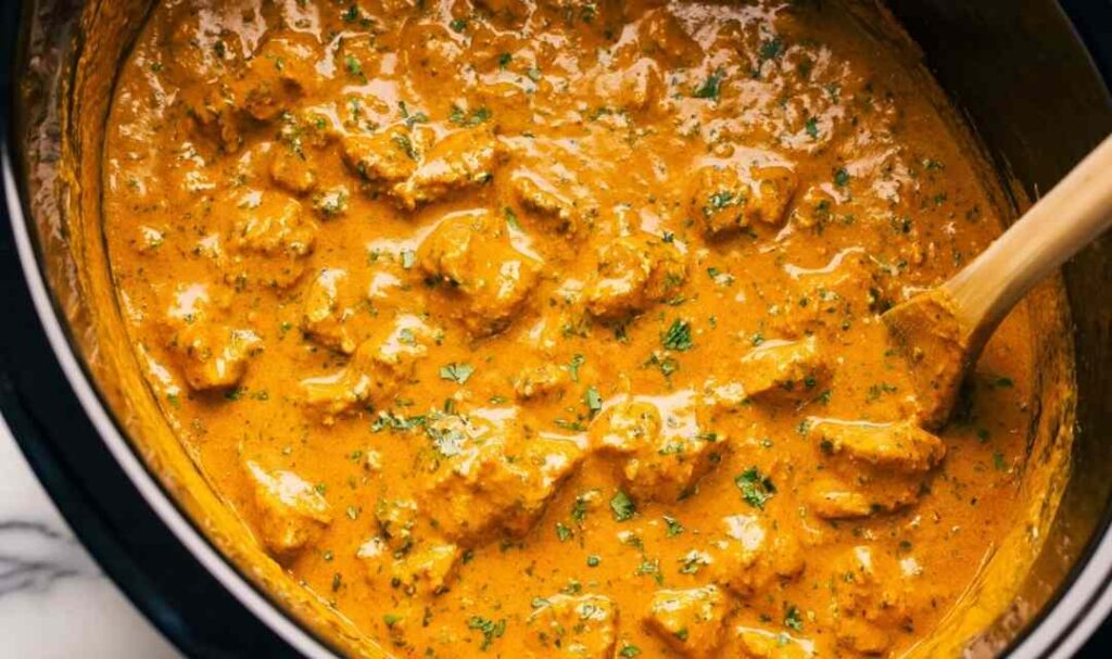 Crockpot Butter Chicken 5 Crockpot butter chicken served over basmati rice with warm naan and fresh cilantro garnish