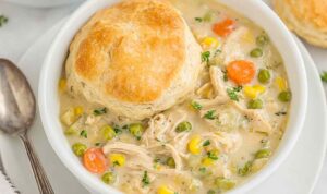 Crockpot chicken pot pie with golden biscuits on top in slow cooker