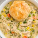 Crockpot chicken pot pie with golden biscuits on top in slow cooker