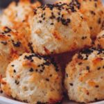 Everything bagel cottage cheese bites in white bowl topped with fresh chives and sesame seeds