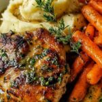 Garlic herb chicken and carrot plate on white dish with fresh parsley garnish