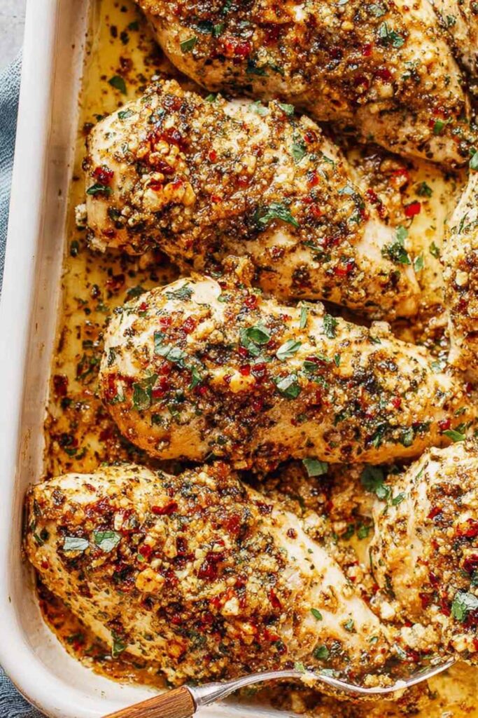Garlic parmesan chicken bake on white plate with golden crispy crust and fresh parsley garnish