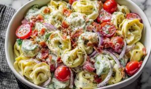 Fresh Grinder Tortellini Salad Fresh grinder tortellini salad with salami, pepperoni, provolone, cherry tomatoes, and zesty Italian dressing in a large white bowl