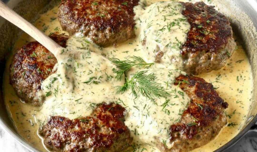 Hamburger Steak in Creamy Dill Sauce 5 Hamburger steak in creamy dill sauce served over mashed potatoes in a cast iron skillet