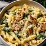 Healthy garlic parmesan chicken pasta in white bowl with fresh parsley garnish