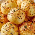 High protein bagel bites arranged on white plate with everything bagel seasoning topping