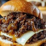 French Onion Beef Sloppy Joes topped with melted Swiss cheese on toasted bun
