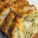 Italian Herbs and Cheese Bread with melted mozzarella and Parmesan on baking sheet
