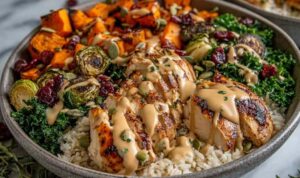 Maple Dijon Chicken Sweet Potato Bowls with roasted sweet potatoes, sliced chicken breast, spinach, and cranberries