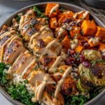 Maple Dijon Chicken Sweet Potato Bowls with roasted sweet potatoes, sliced chicken breast, spinach, and cranberries