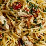 Creamy Monterey chicken spaghetti in a white baking dish topped with melted Monterey Jack and cheddar cheese