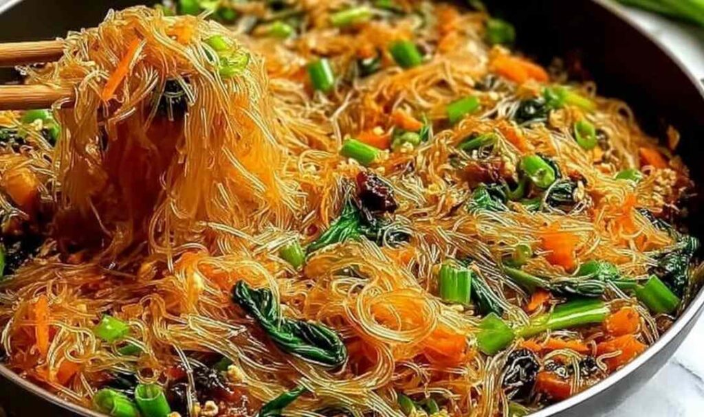 High protein rice noodle stir fry with chicken and vegetables in a wok