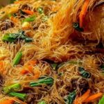 High protein rice noodle stir fry with chicken and vegetables in a wok