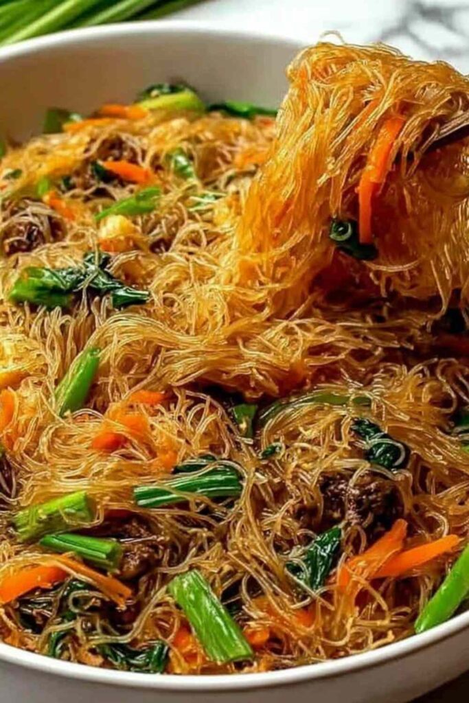 High protein rice noodle stir fry with chicken and vegetables in a wok