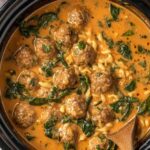 Slow cooker meatball soup in a white bowl topped with fresh parsley and grated Parmesan cheese