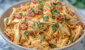 Slow cooker queso chicken tacos in soft flour tortillas topped with fresh cilantro and avocado