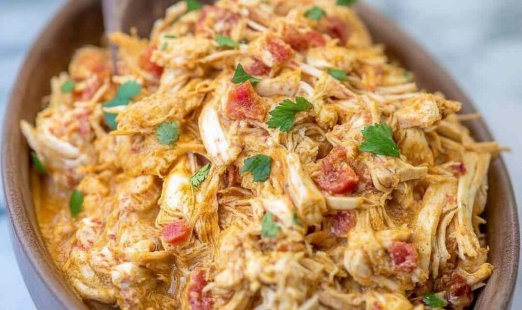 Slow cooker queso chicken tacos in soft flour tortillas topped with fresh cilantro and avocado