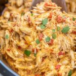 Slow cooker queso chicken tacos in soft flour tortillas topped with fresh cilantro and avocado