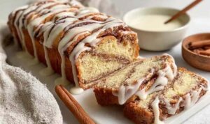 Sliced sourdough discard cinnamon bread showing cinnamon swirl on a wooden cutting board