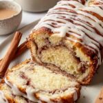 Sliced sourdough discard cinnamon bread showing cinnamon swirl on a wooden cutting board