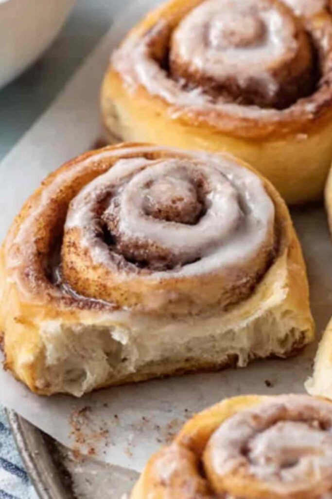 Freshly baked sourdough discard cinnamon rolls with white icing in a baking dish