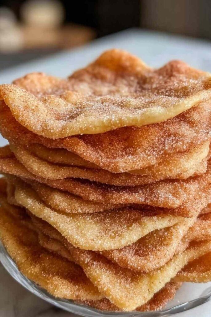 Sourdough discard cinnamon sugar crisps on white plate with coffee cup