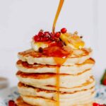 Stack of fluffy sourdough discard pancakes with butter and maple syrup dripping down the sides
